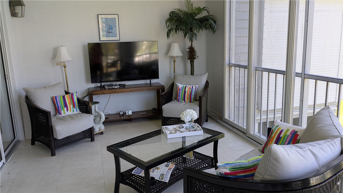 1903 Bay Road, Unit 206 Vero Beach, FL 32963 - Photo 4 of 30 a living room with furniture and a flat screen tv