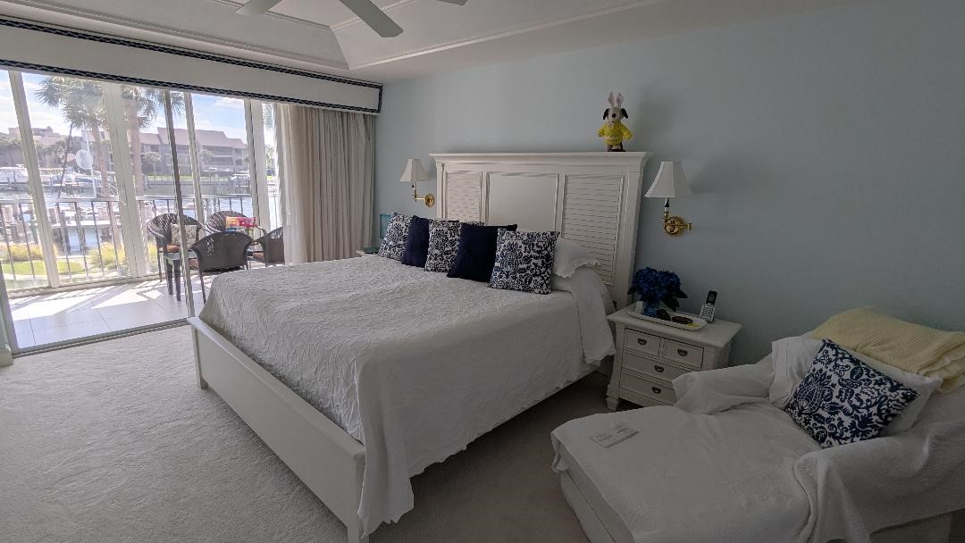 1903 Bay Road, Unit 206 Vero Beach, FL 32963 - Photo 10 of 30 a bedroom with a bed and large windows