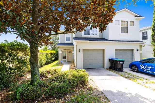 a view of a house with a large tree in front of it
