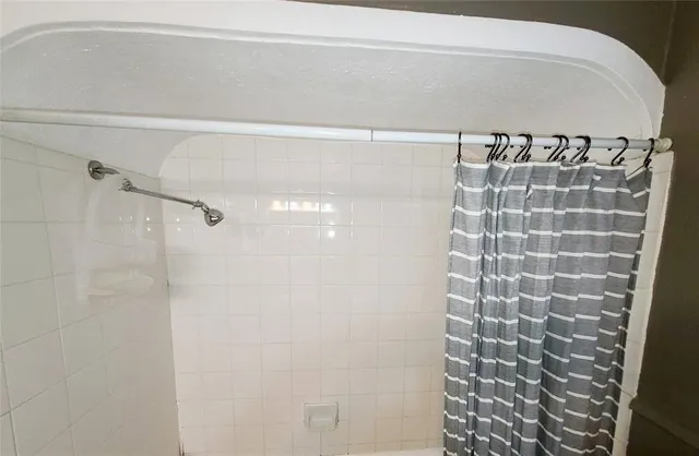 a bathroom with a shower and a sink