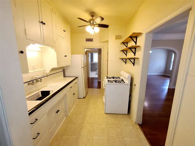 a view of a kitchen with a sink and a refrigerator