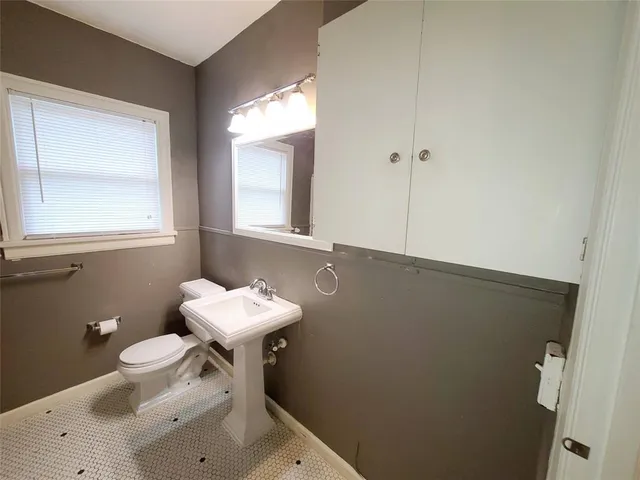a bathroom with a sink toilet and a mirror