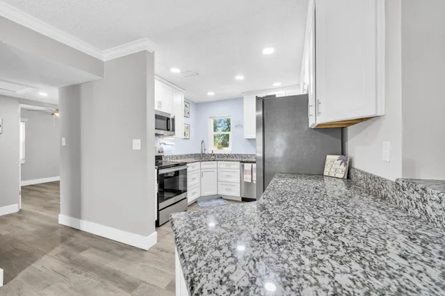 a kitchen with stainless steel appliances granite countertop a stove a sink and a refrigerator