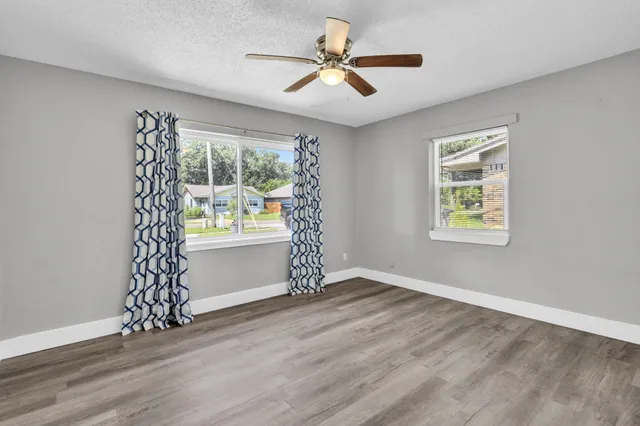 a view of an empty room with window chandelier fan