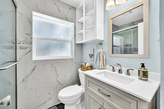 a bathroom with a sink a toilet and a mirror