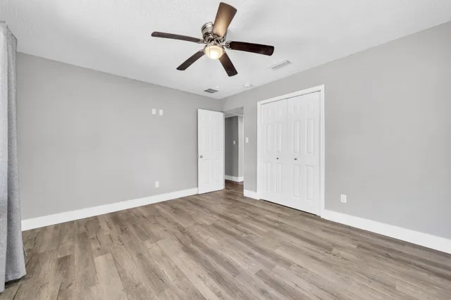 a view of empty room with wooden floor