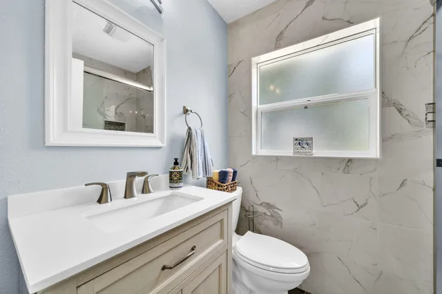 a bathroom with a toilet a sink and mirror