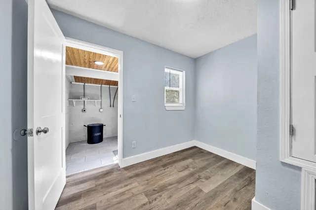an empty room with wooden floor and a window