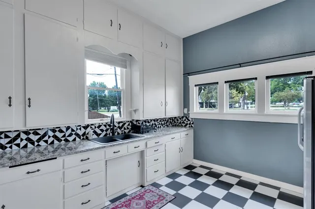 a kitchen with a sink window and cabinets