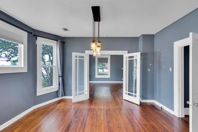 a view of a room with wooden floor fireplace and window