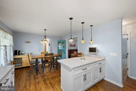 a view of kitchen and dining room with furniture window and wooden floor