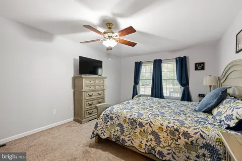 a bedroom with a bed and a flat tv screen on a dresser
