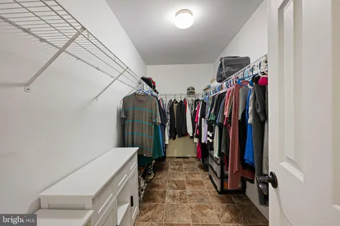 a view of walk in closet with clothes