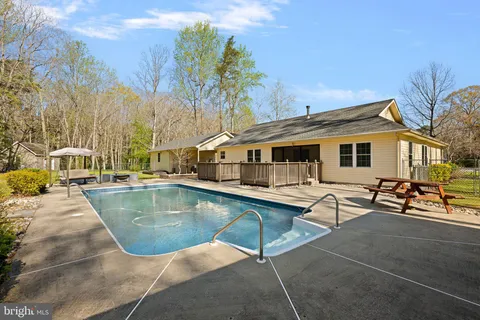 a view of a house with pool and sitting area