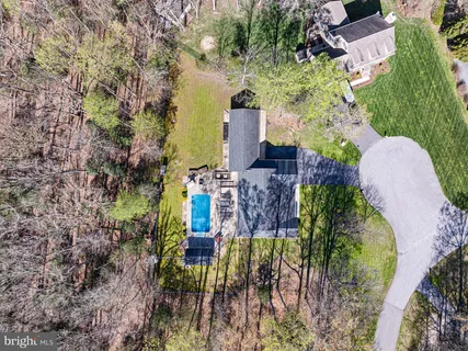 an aerial view of a house with a yard and large trees