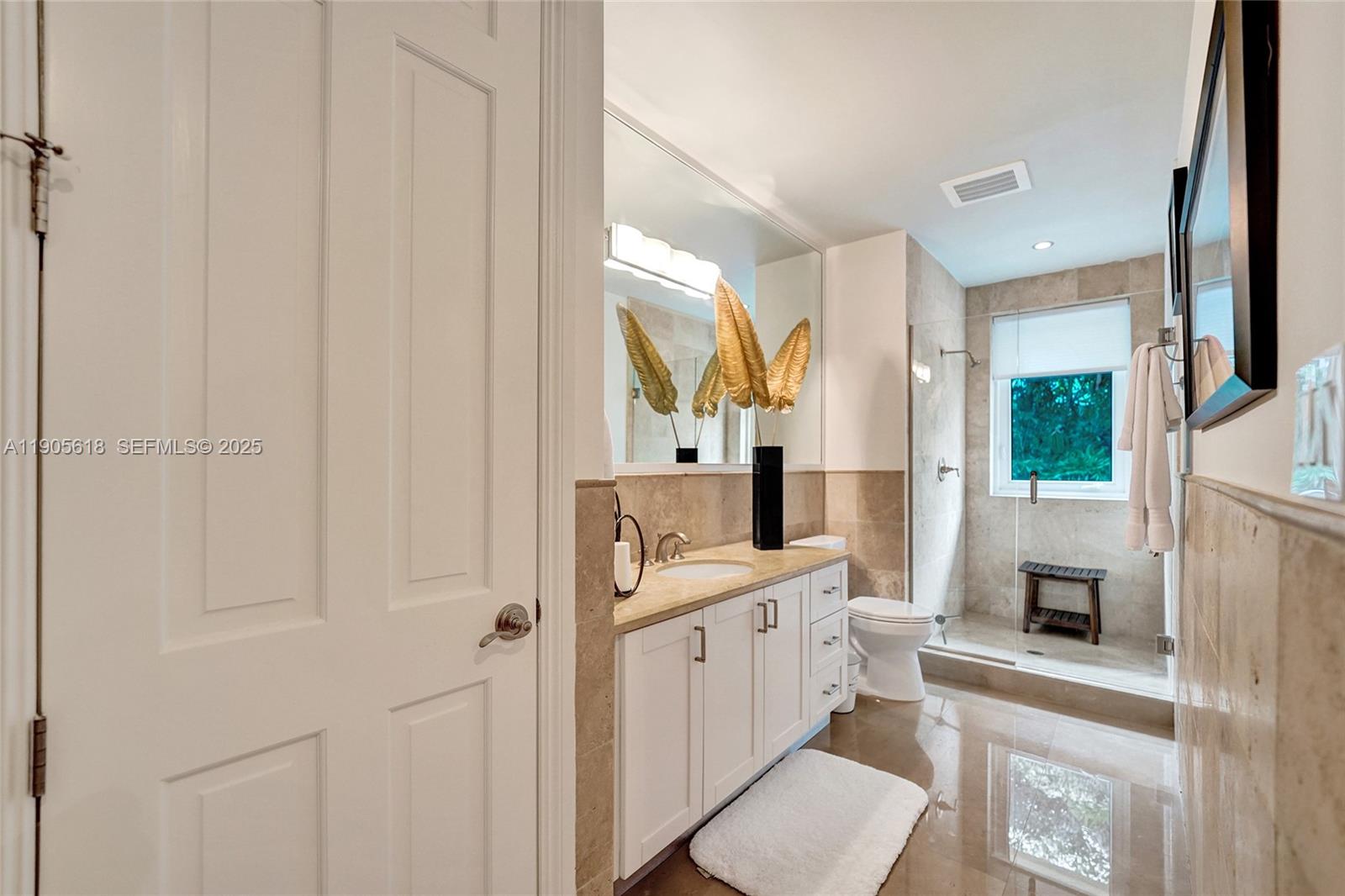 516 Hendricks Isle, Unit 2C Fort Lauderdale, FL 33301 - Photo 48 of 77 a bathroom with a sink a toilet and a mirror
