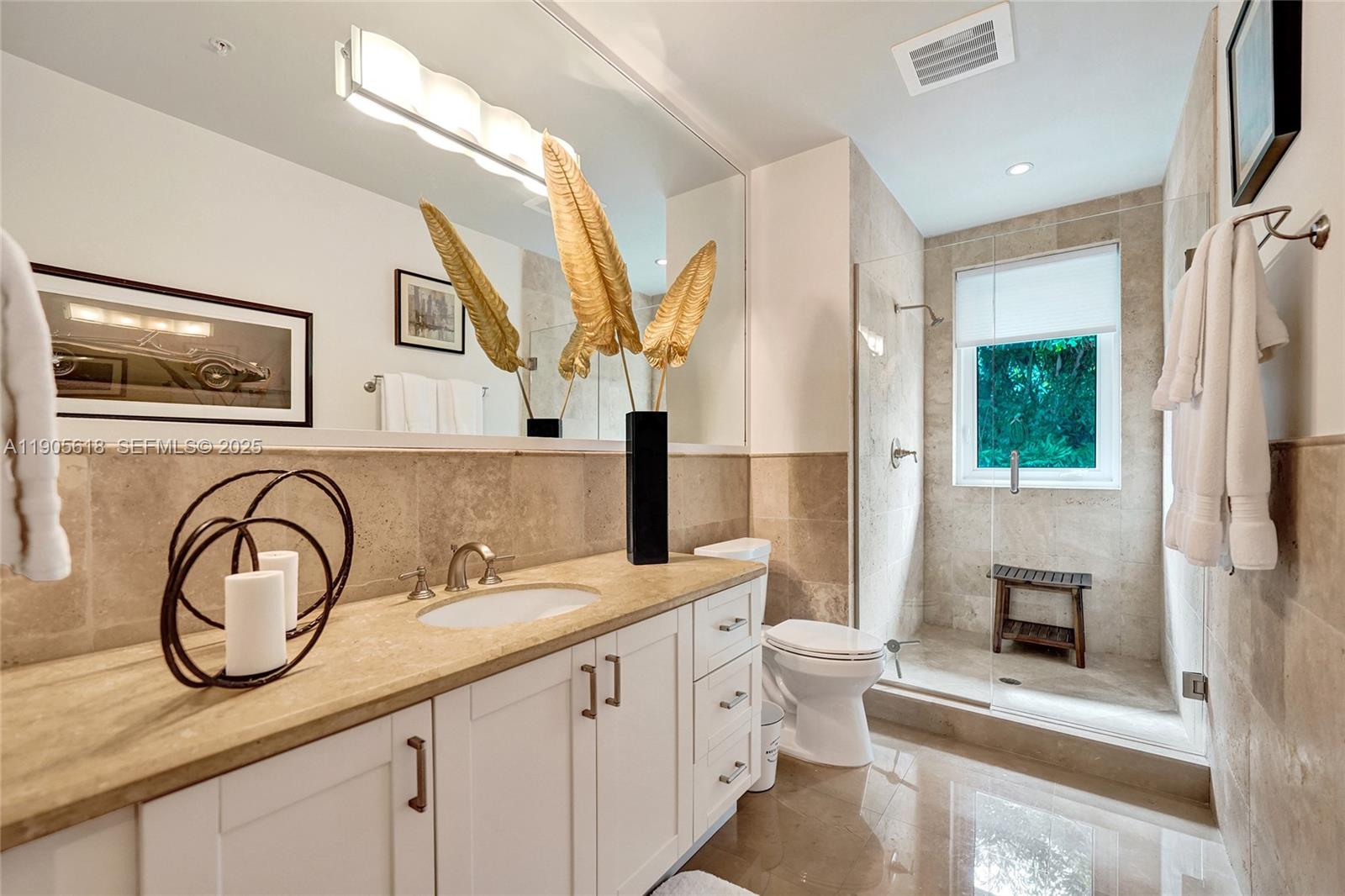 516 Hendricks Isle, Unit 2C Fort Lauderdale, FL 33301 - Photo 49 of 77 a bathroom with a double vanity sink a toilet and a mirror