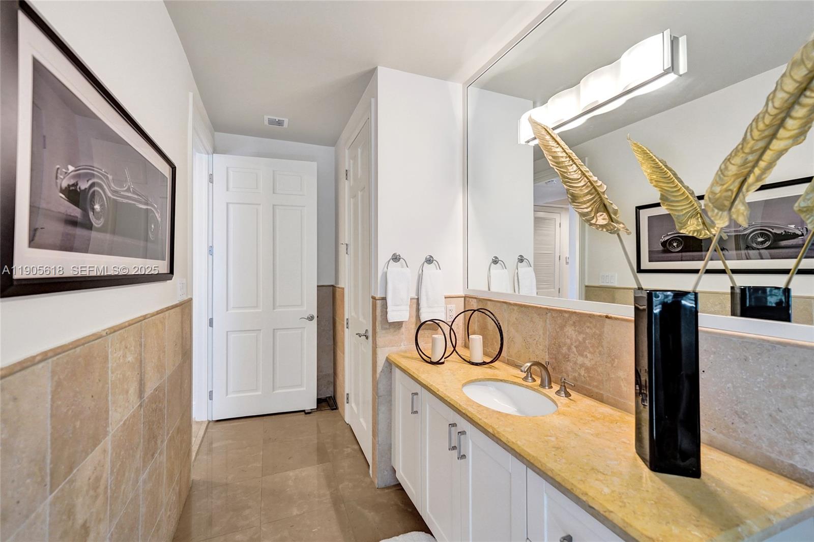 516 Hendricks Isle, Unit 2C Fort Lauderdale, FL 33301 - Photo 50 of 77 a bathroom with a granite countertop sink and a mirror