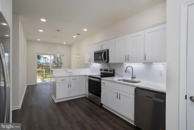 a kitchen with a sink stove cabinets and refrigerator