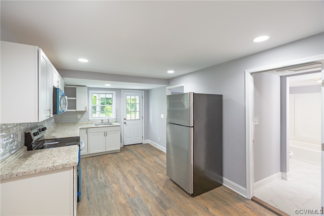 2440 Dupuy Road Petersburg, VA 23803 - Photo 15 of 25 a kitchen with a refrigerator a sink and wooden floor
