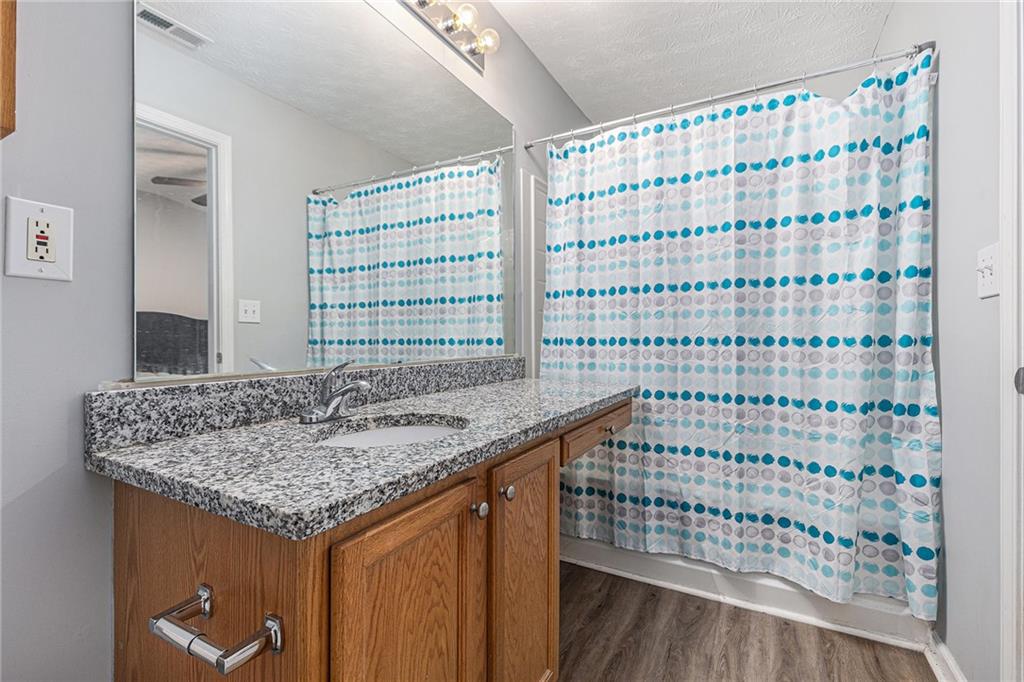 6536 Arbor Gate Drive Southwest, Unit 2 Mableton, GA 30126 - Photo 21 of 27 a bathroom with a granite countertop sink and a shower