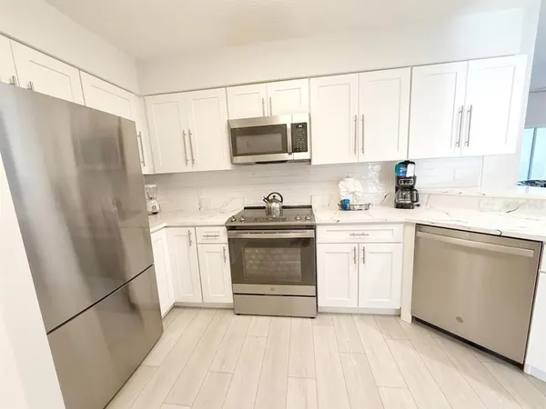 a kitchen with a sink a refrigerator a microwave and cabinets
