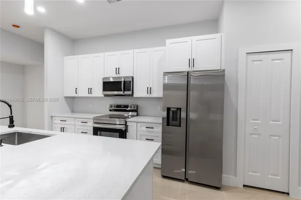 a kitchen with a refrigerator stove and sink