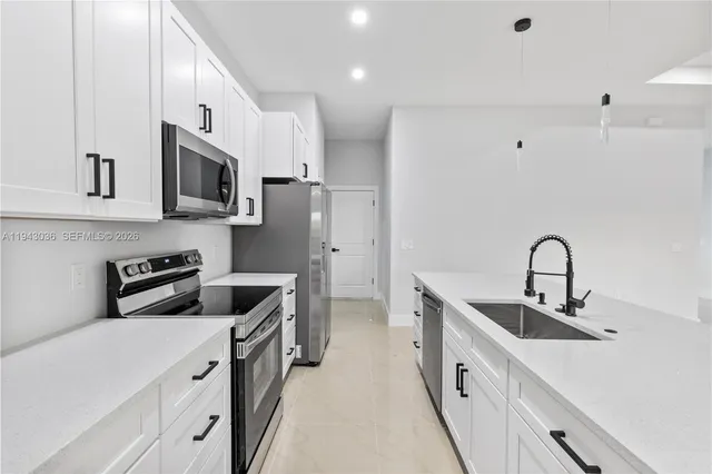 a kitchen with stainless steel appliances white cabinets and a sink