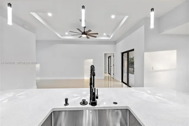 a view of a kitchen with a sink and chandelier