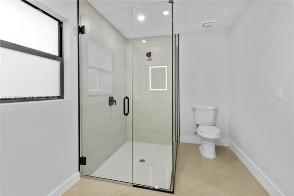 a bathroom with a toilet and a shower