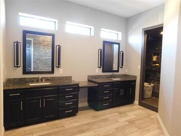 a spacious bathroom with a granite countertop double vanity and a mirror