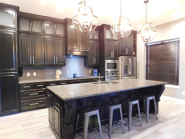 a kitchen with stainless steel appliances granite countertop a stove a sink and a refrigerator