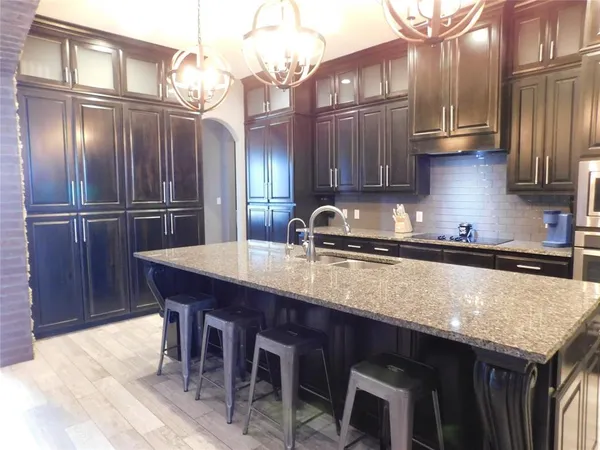 a kitchen with stainless steel appliances granite countertop a sink a table and chairs