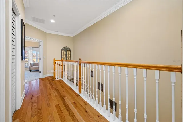 a view of a hallway with wooden floor and staircase