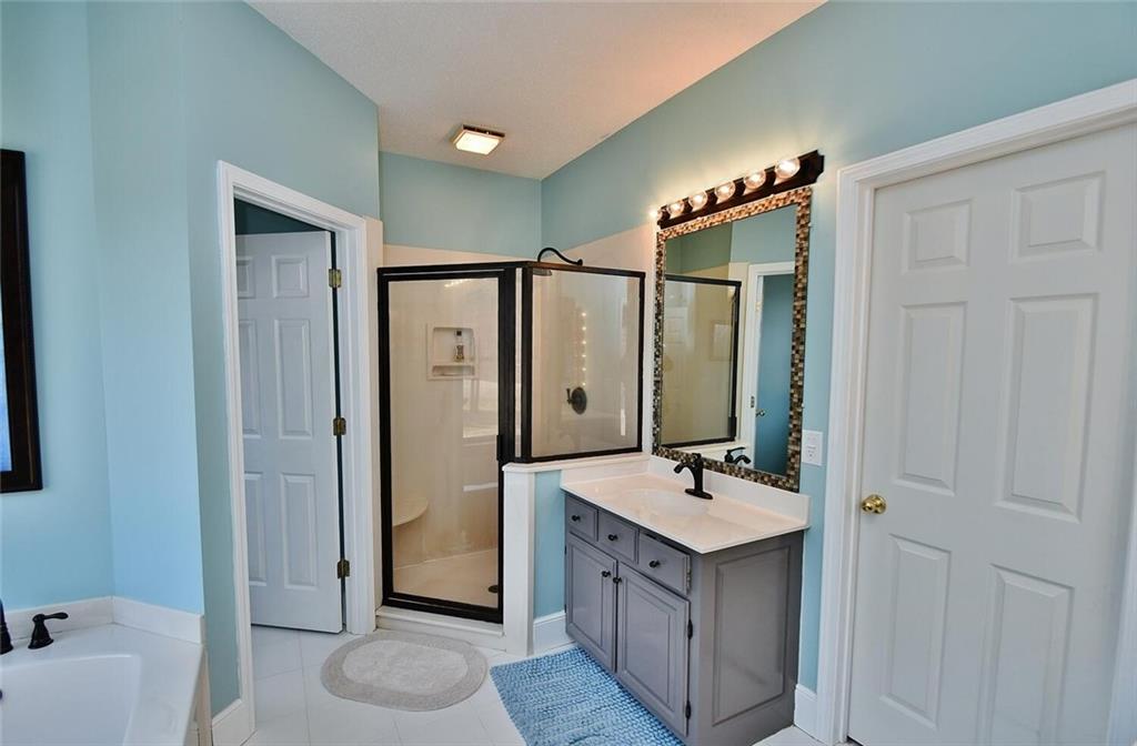 184 Scott Circle Toccoa, GA 30577 - Photo 19 of 52 a bathroom with a double vanity sink a mirror and a shower