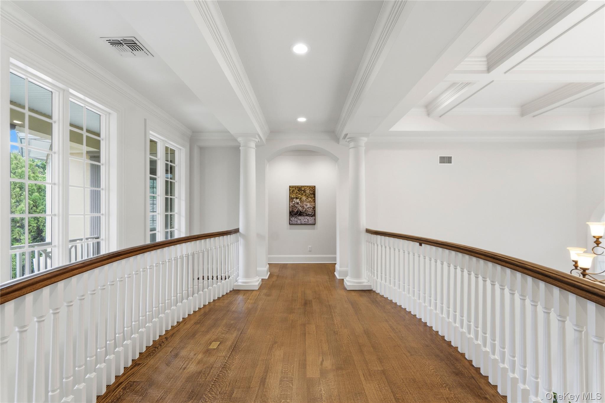 1960 Midlane Road South Syosset, NY 11791 - Photo 35 of 46 a view of a hallway with wooden floor and chandelier