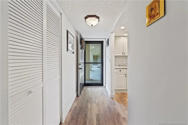 a view of a hallway with wooden floor and closet