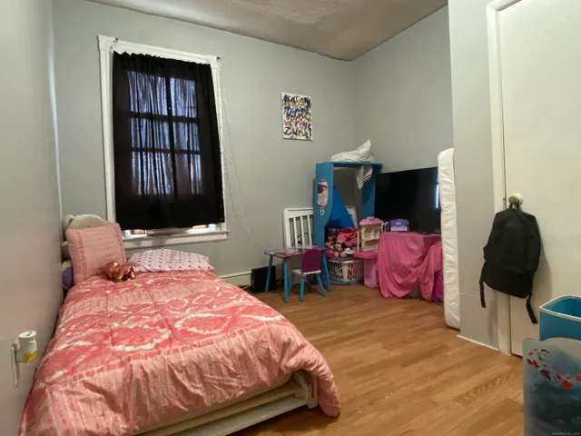 a bedroom with a bed and wooden floor