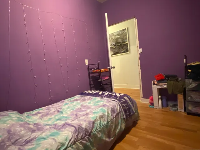 a bedroom with a bed and a painting on the wall