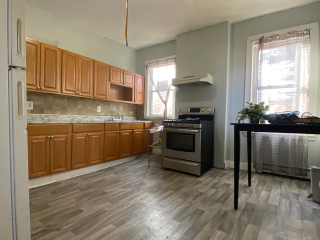 a kitchen with stainless steel appliances granite countertop a stove a sink and a refrigerator