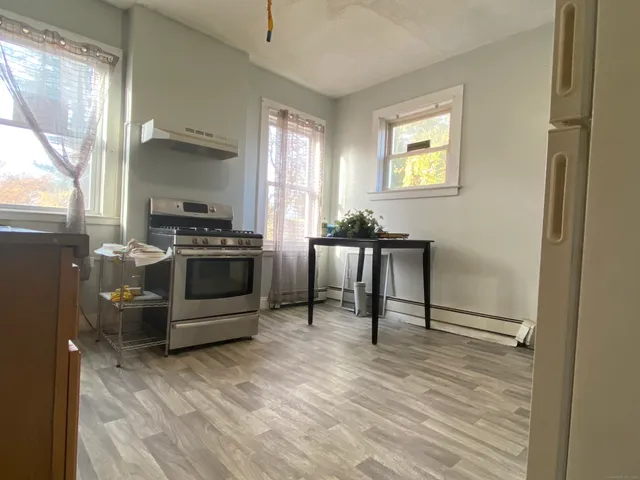 a kitchen with a stove a refrigerator and a stove top oven