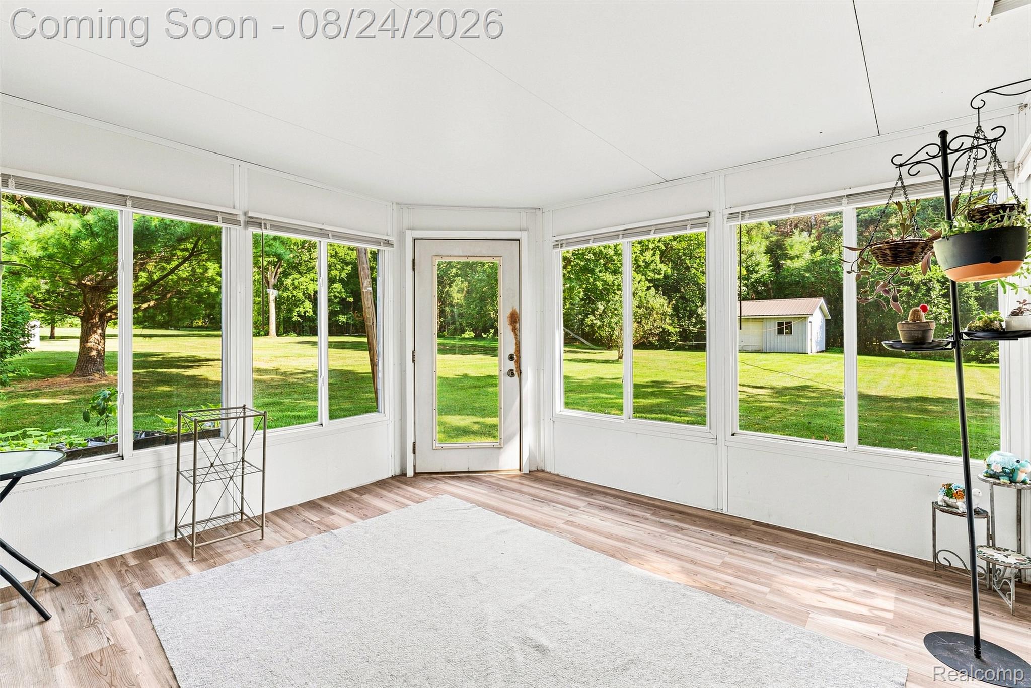 2310 Peppermill Road Lapeer, MI 48446 - Photo 23 of 35 Sunroom with wood-finish flooring, multiple large windows, and a glass-paneled door
