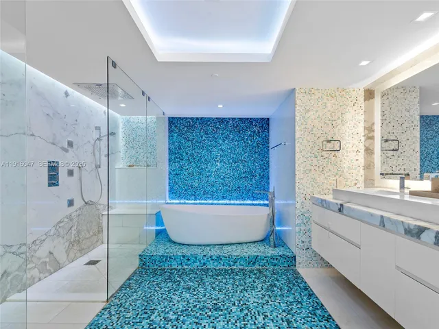 a bathroom with a tub a window and a shower