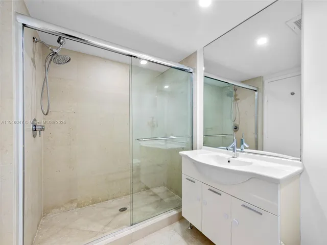 a bathroom with a shower sink vanity and mirror