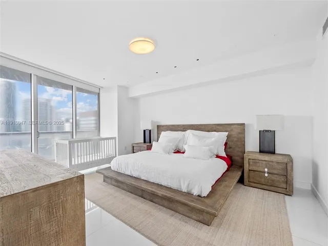 a bedroom with a bed and a large window