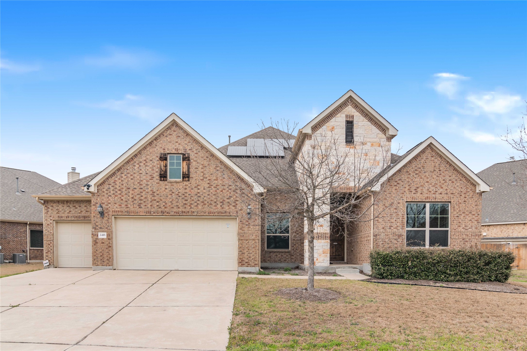 2416 Millbrook Loop Leander, TX 78641 - Photo 1 of 1 Traditional home featuring solar panels, concrete driveway, a garage, brick siding, and central AC unit