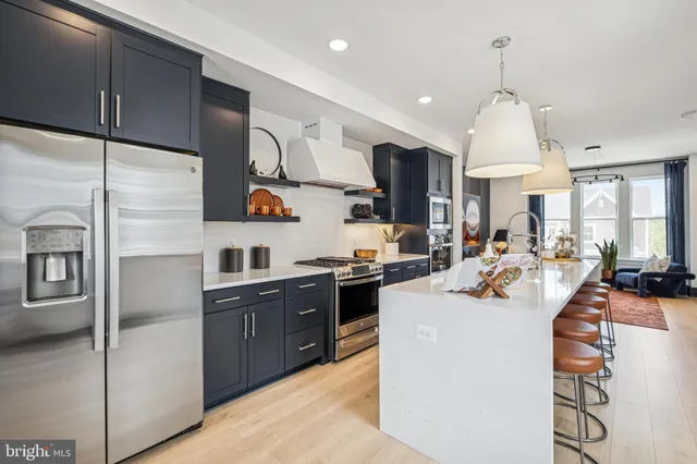a kitchen with kitchen island granite countertop a sink appliances cabinets and a counter top space