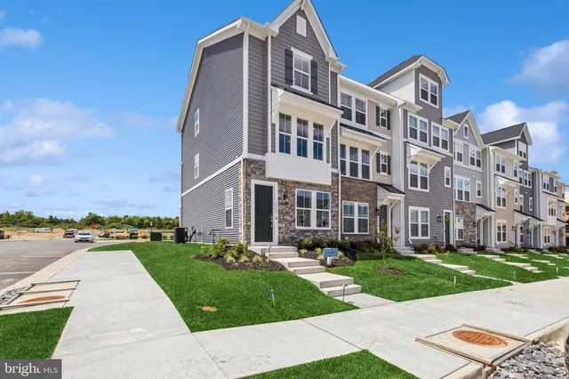 a front view of a building with garden and trees