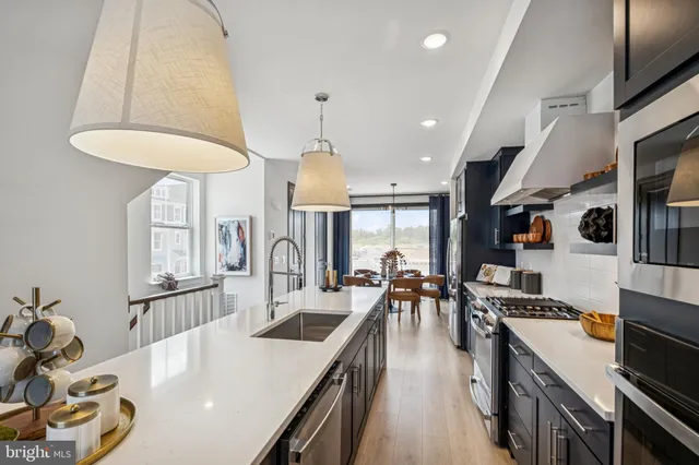 a kitchen with stainless steel appliances granite countertop a sink a stove and a refrigerator