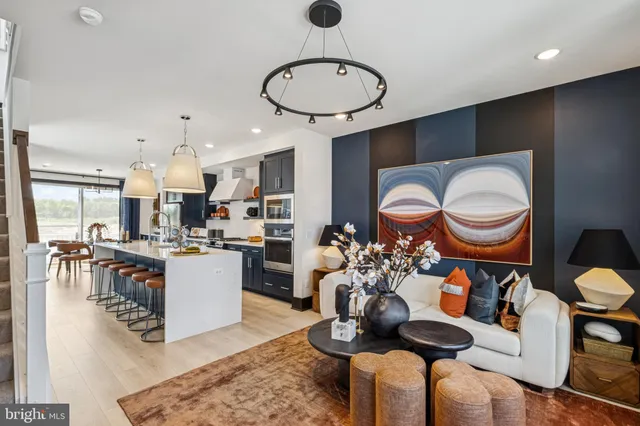 a living room with dining table a couch and a chandelier